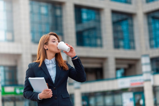 Hermosa mujer de negocios bebiendo café para salir al aire libre