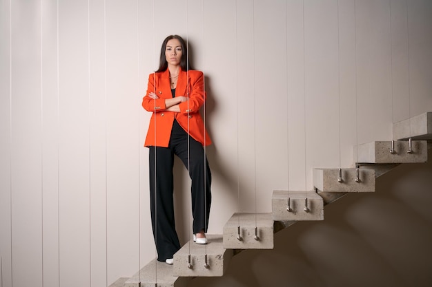 Foto hermosa mujer de negocios en las escaleras con chaqueta roja está experimentando un colapso