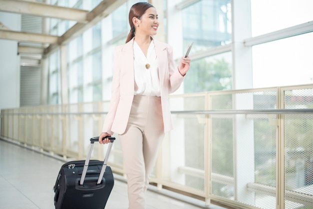 Hermosa mujer de negocios está caminando en el aeropuerto