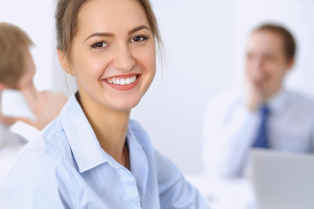 Hermosa mujer de negocios en el fondo de la gente de negocios durante la reunión