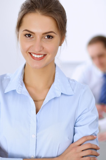 Hermosa mujer de negocios en el fondo de la gente de negocios durante la reunión