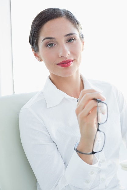 Hermosa mujer de negocios joven sentado en el sofá