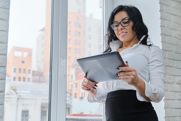 Hermosa mujer de negocios de moda con tableta digital