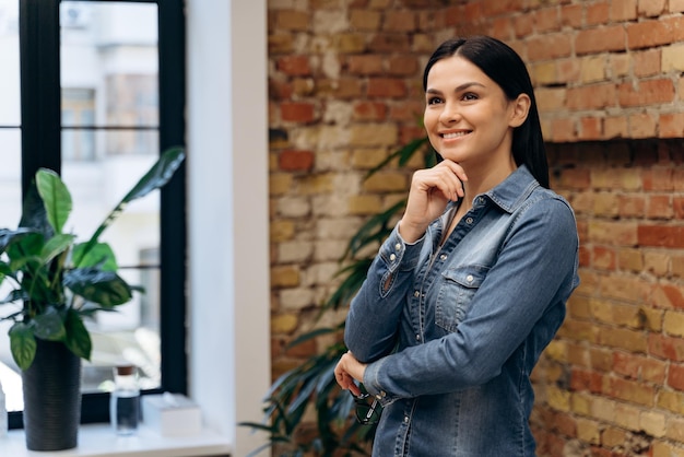 Hermosa mujer de negocios morena pensando en algo en el interior