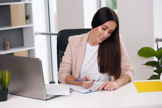 Hermosa mujer de negocios ocupada en la oficina