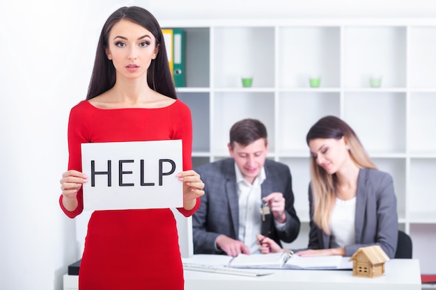 La hermosa mujer de negocios en la oficina pide ayuda.