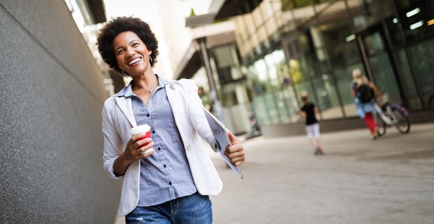 Hermosa mujer de negocios profesional feliz sonriendo feliz con tableta al aire libre