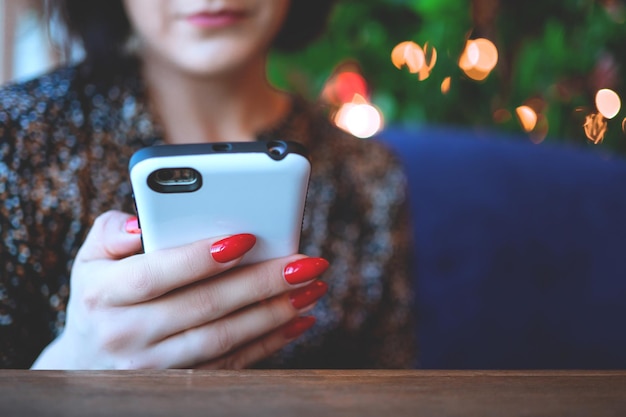 Hermosa mujer de negocios en el restaurante llama a tu teléfono inteligente Linda morena en un café