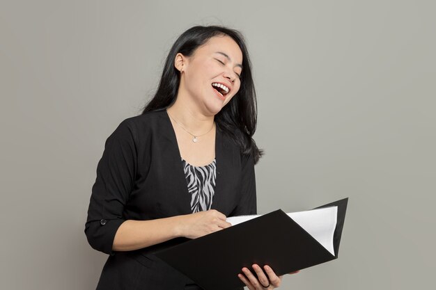 Hermosa mujer de negocios riendo mientras sostiene la carpeta