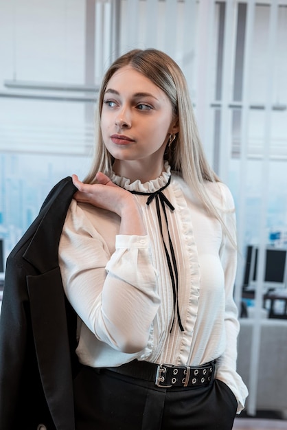 Hermosa mujer de negocios rubia en una blusa blanca en el edificio de oficinas Estilo de vida de retrato de moda