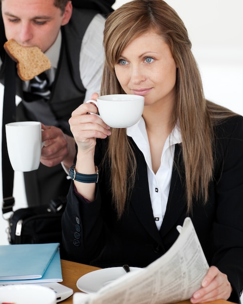 Hermosa mujer de negocios tomando café mientras su marido se apresura