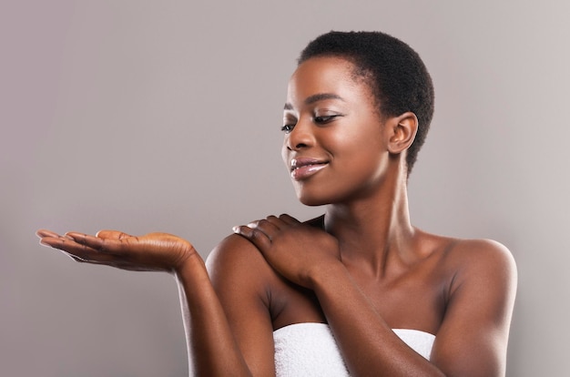 Hermosa mujer negra demostrando algo en su palma abierta