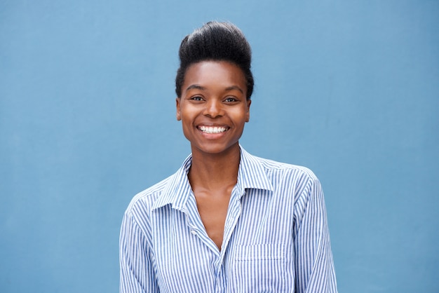 Hermosa mujer negra joven sonriendo sobre fondo azul