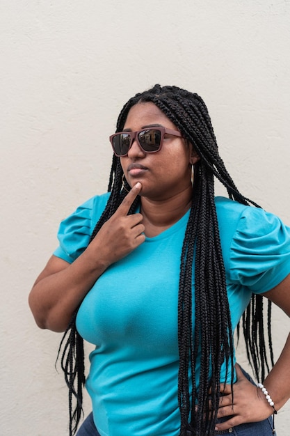 Hermosa mujer negra con largas trenzas y blusa azul.