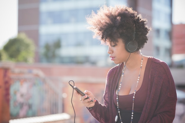 hermosa mujer negra de pelo rizado escuchando música