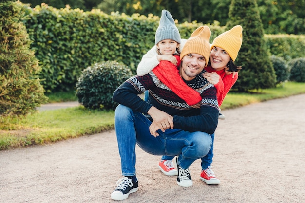 Hermosa mujer, niña abraza a su guapo padre y esposo