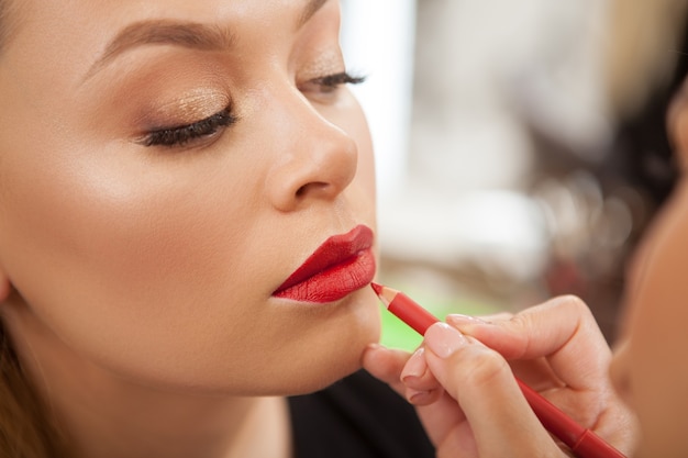 Hermosa mujer obteniendo maquillaje profesional