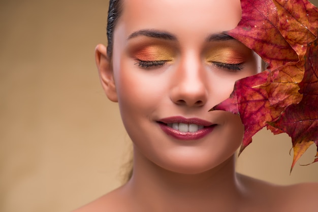 Hermosa mujer en otoño con hojas secas