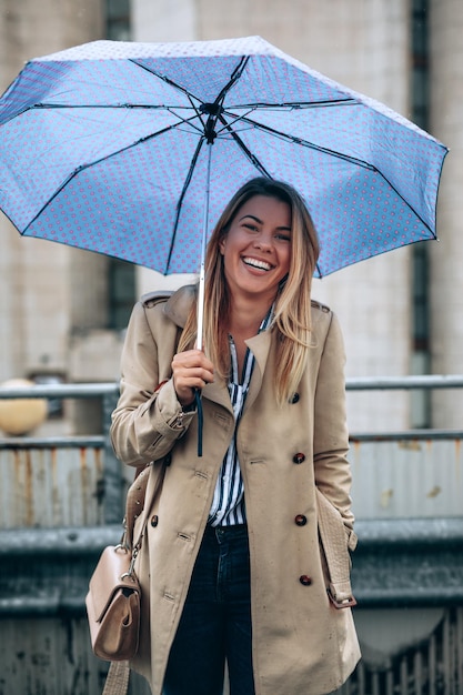 Hermosa mujer con paraguas en un día lluvioso