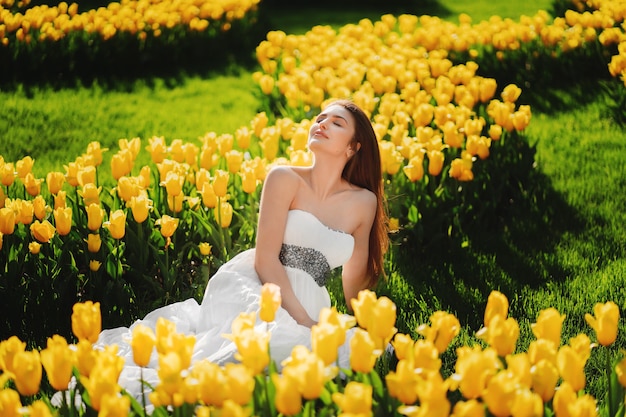 Hermosa mujer en un paseo por el campo de tulipanes en flor