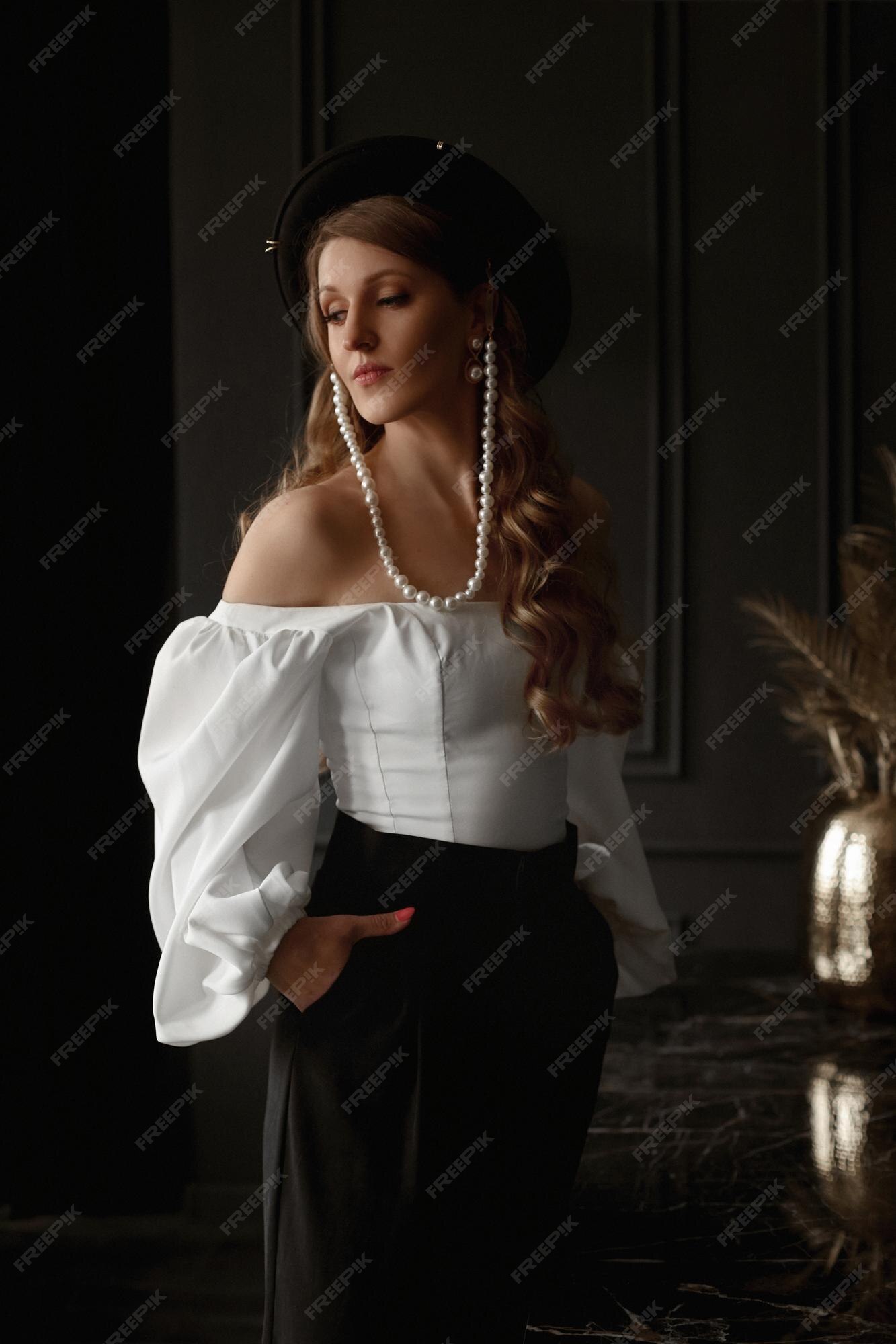 Hermosa mujer con un peinado elegante con un sombrero negro de moda y una  blusa blanca en el estilo minimalista... | Foto Premium