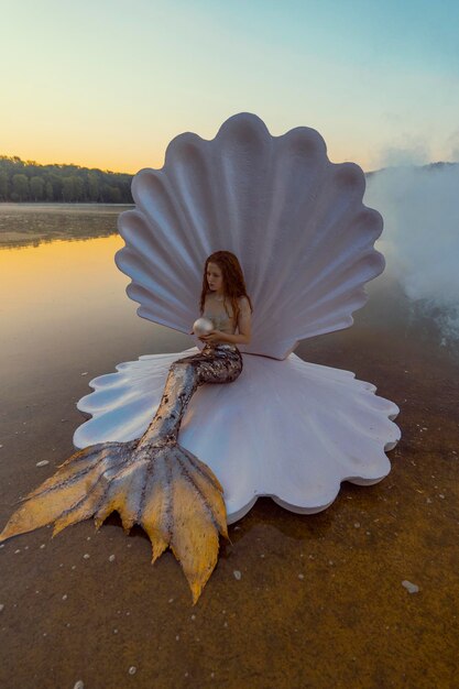 Una hermosa mujer pelirroja como sirena con una concha gigante