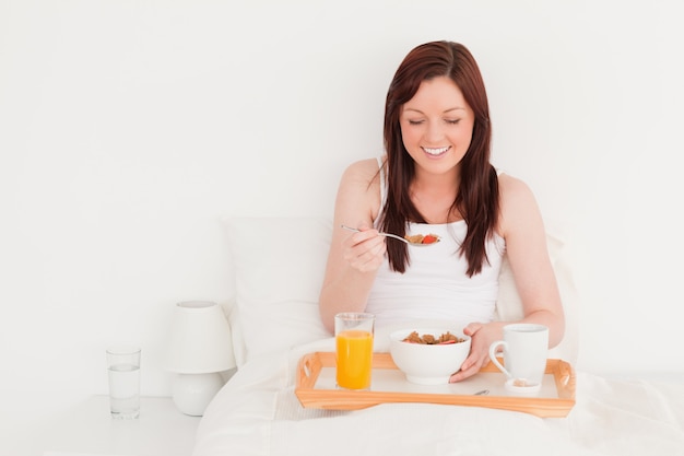 Hermosa mujer pelirroja desayunando