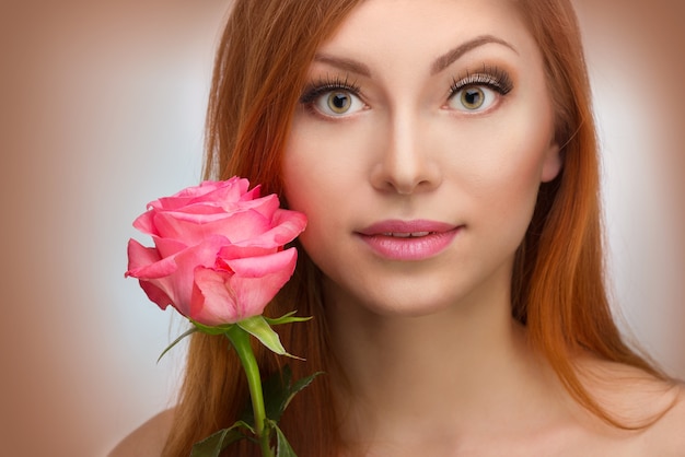 Hermosa mujer pelirroja con una rosa