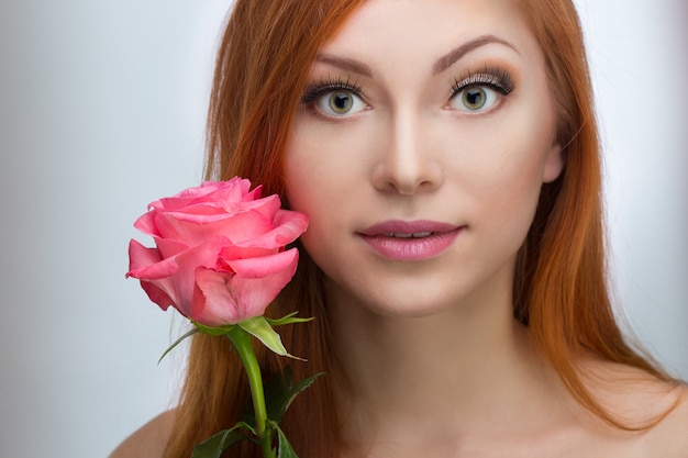 Hermosa mujer pelirroja con una rosa