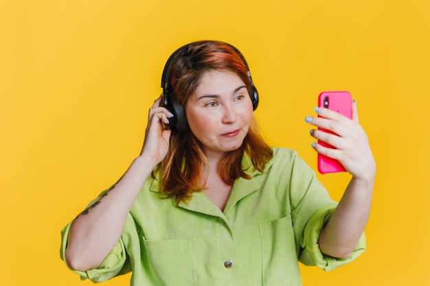 Hermosa mujer pelirroja se toma una selfie con auriculares