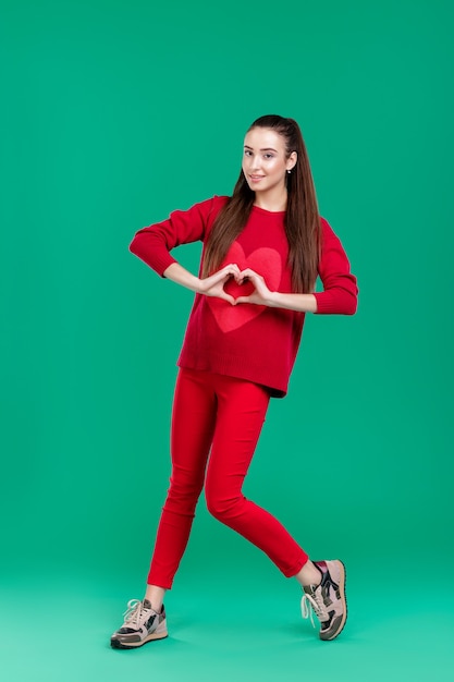 Hermosa mujer con pelo largo en suéter rojo aislado