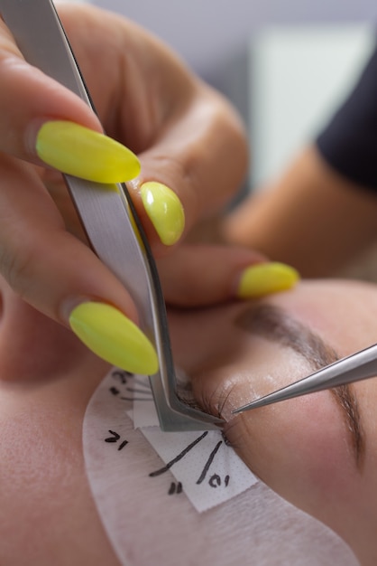 Hermosa mujer con pestañas largas en un salón de belleza procedimiento de extensión de pestañas pestañas de cerca