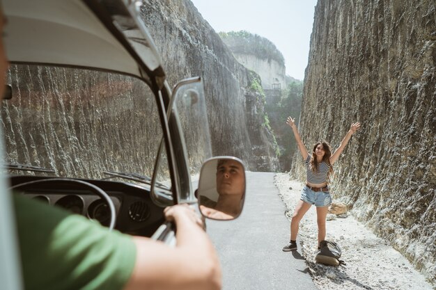 Foto hermosa mujer de pie en una carretera con levantar las manos