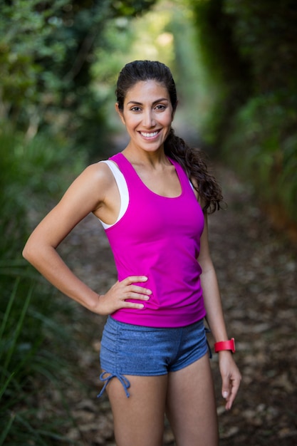 Hermosa mujer de pie con la mano en la cadera en el bosque