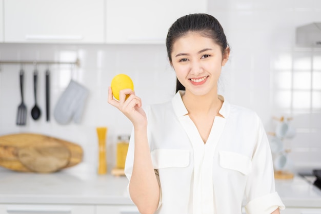 Hermosa mujer de pie sosteniendo un limón.