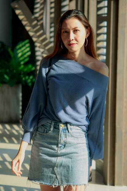 Hermosa mujer de pie en una ventana de madera