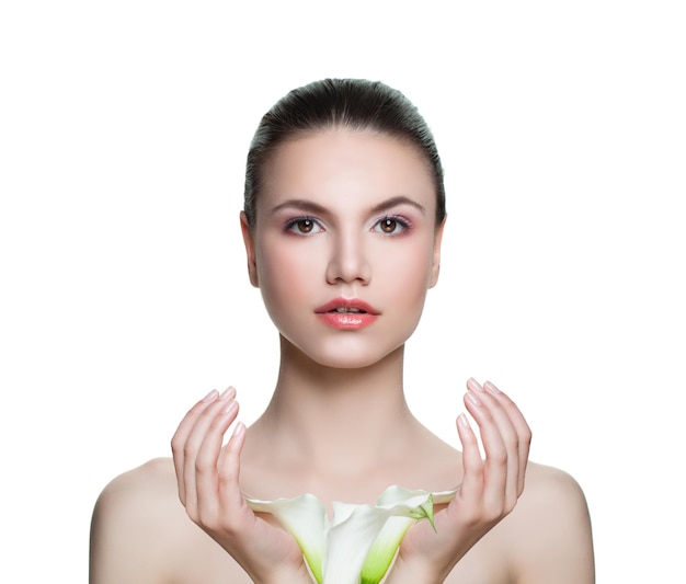 Hermosa mujer con piel clara y flores aisladas en blanco Concepto de cuidado de la piel y tratamiento facial