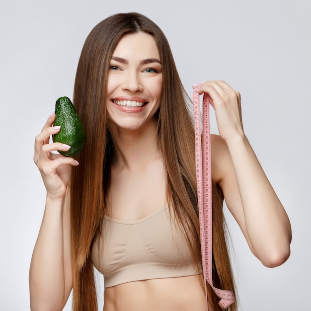 Hermosa mujer con piel limpia y fresca con aguacate