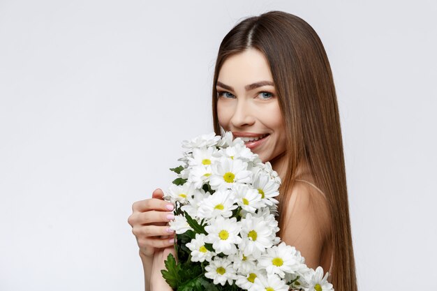 Hermosa mujer con piel limpia y fresca con flores