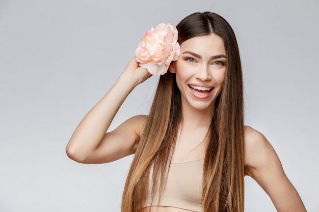 Hermosa mujer con piel limpia y fresca con flores