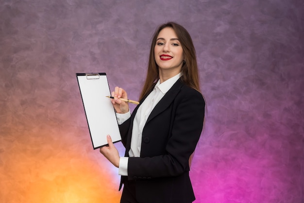 Hermosa mujer con portapapeles ofreciendo firmar un contrato con lápiz