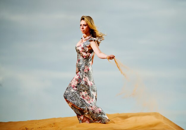 Hermosa mujer posa en el desierto amarillo.