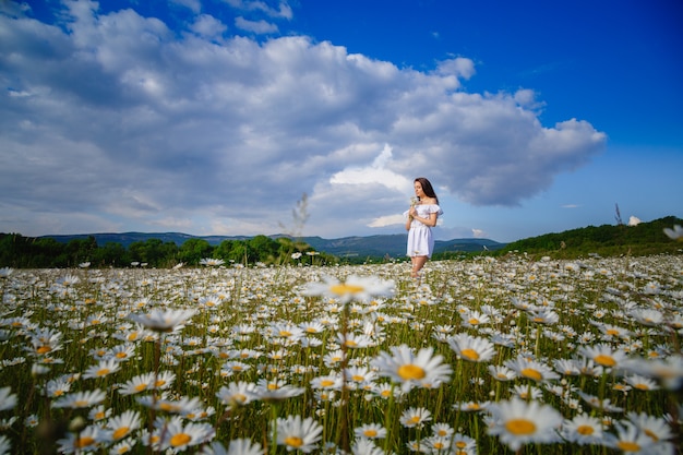 Hermosa mujer posando en un campo con margaritas