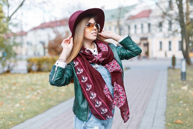 Hermosa mujer posando en el día de otoño. Chica con sombrero y gafas de sol de moda.