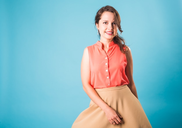 Hermosa mujer posando en el estudio sobre fondo azul con copyspace