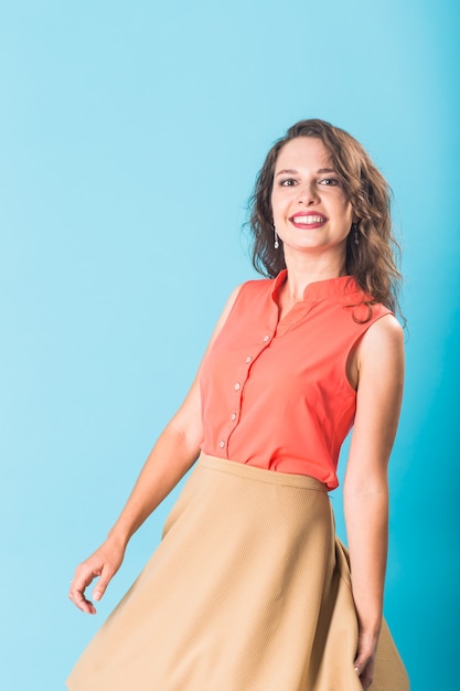 Hermosa mujer posando en el estudio sobre fondo azul.