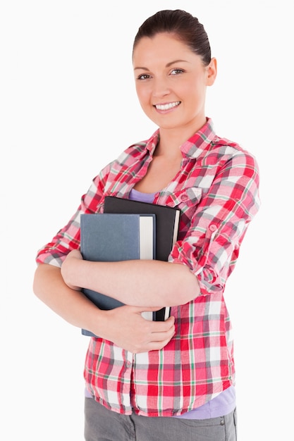 Hermosa mujer posando con libros mientras está de pie