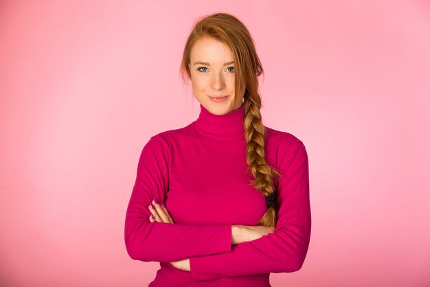 Hermosa mujer posando en pared rosa