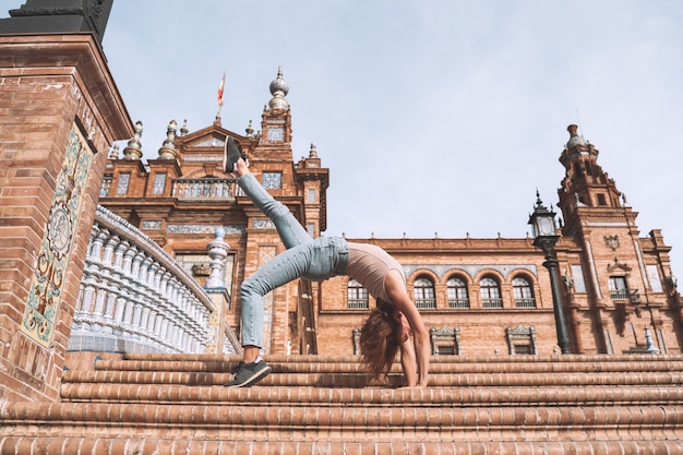 Hermosa mujer en pose de yoga en el puente de la Plaza de España en Sevilla Andalucía España