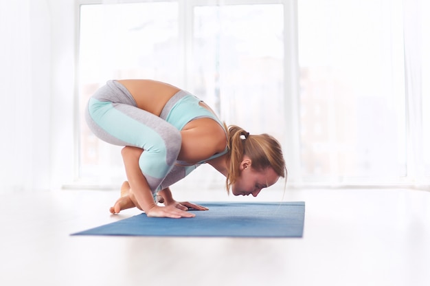 Hermosa mujer practica yoga asana handstand Bhuja Pidasana